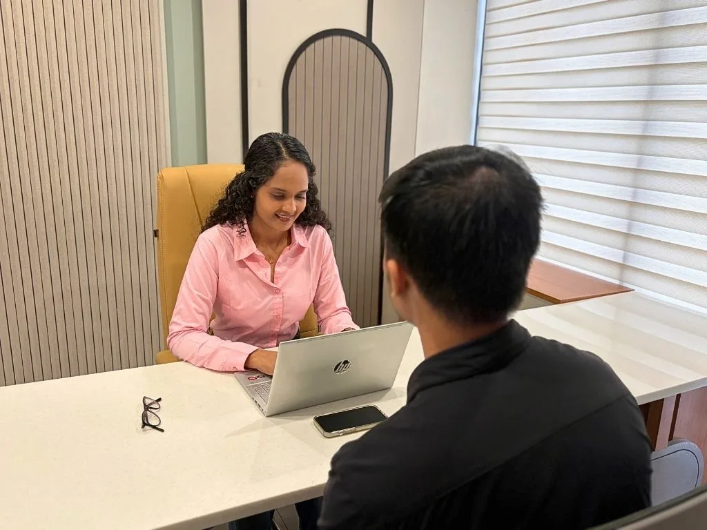 Riddhi consulting with a client across the desk at the clinic
