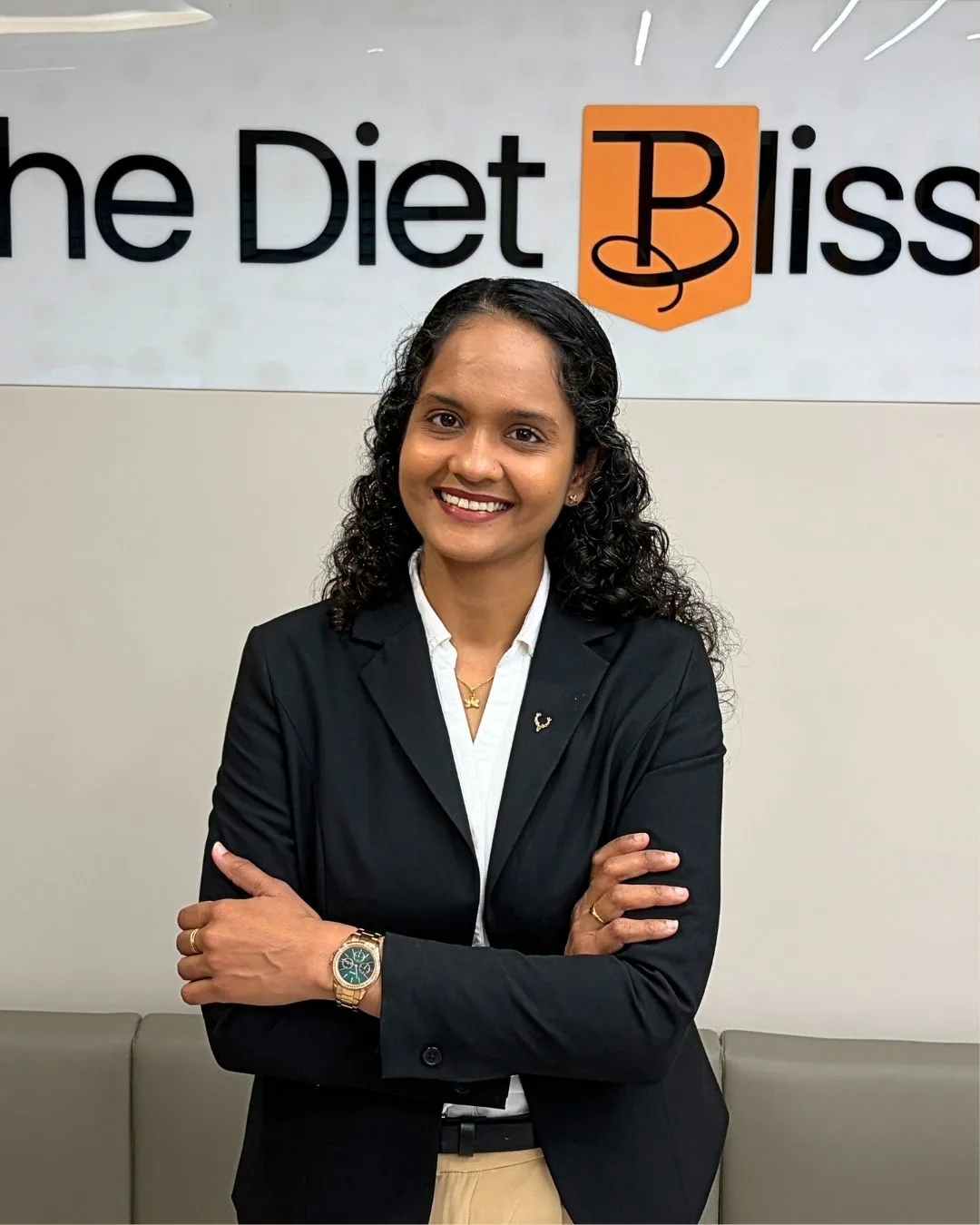 Riddhi in front of The Diet Bliss logo wall