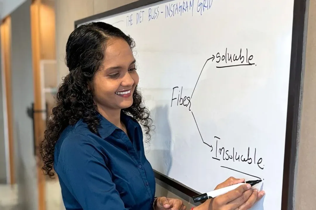 Riddhi mapping out an Instagram content grid on a whiteboard at the clinic