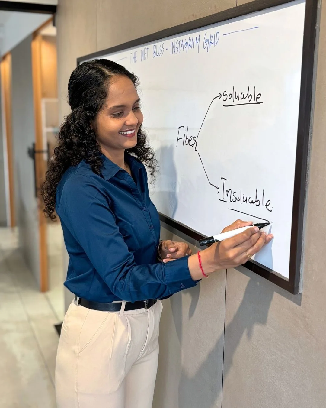 Riddhi explaining soluble and insoluble fibre at a whiteboard